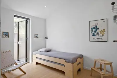 a bedroom with a bed and a chair and a window at LK1272-Lokken-Ruthsvej-17 in Løkken