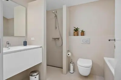 a white bathroom with a toilet and a sink at LK1272-Lokken-Ruthsvej-17 in Løkken