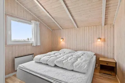 a bedroom with a large bed in a room with a window at LK431-Lokken-Kettrup-Bjerge-Vej-62 in Løkken