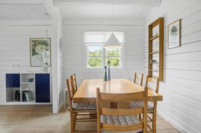 a dining room with a wooden table and chairs at LK1955-Lokken-Laurasvej-10 in Løkken
