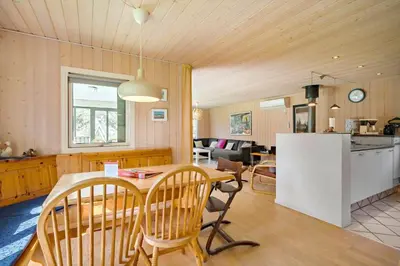 a kitchen and living room with a table and chairs at LK1354-Lokken-Madsinesvej-4 in Løkken