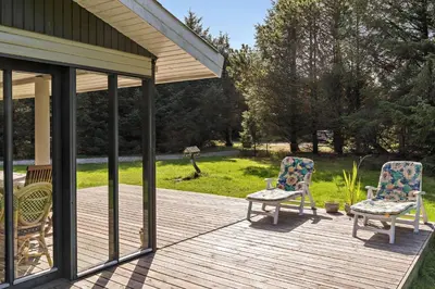 two chairs sitting on a wooden deck with a yard at LK1354-Lokken-Madsinesvej-4 in Løkken