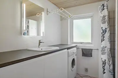 a bathroom with a sink and a washing machine at LK1354-Lokken-Madsinesvej-4 in Løkken