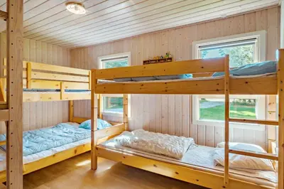 two bunk beds in a room with wooden walls at LK1354-Lokken-Madsinesvej-4 in Løkken