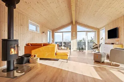 a living room with a fireplace and a couch at LK2112-Lokken-Kettrup-Bjerge-Vej-64 in Løkken