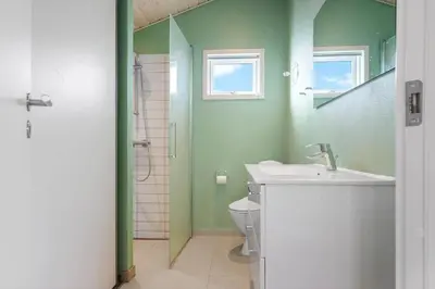 a green bathroom with a sink and a toilet at LK2112-Lokken-Kettrup-Bjerge-Vej-64 in Løkken