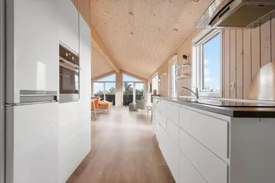 a kitchen with white cabinets and a wooden ceiling at LK2112-Lokken-Kettrup-Bjerge-Vej-64 in Løkken