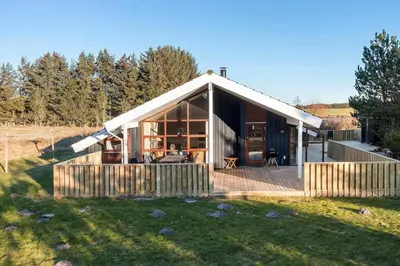 a small house with a deck in a field at LK933-Lokken-Olgavej-34 in Løkken