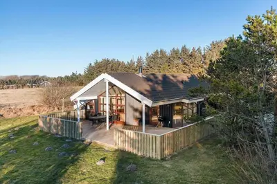 a small house with a deck in a field at LK933-Lokken-Olgavej-34 in Løkken