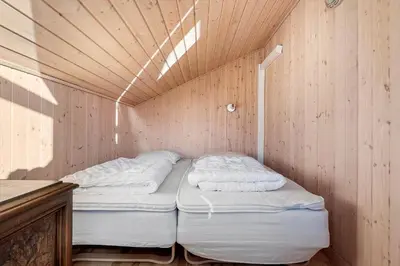 a small room with two beds in a wooden wall at LK933-Lokken-Olgavej-34 in Løkken