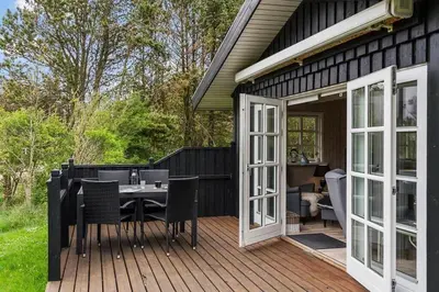 a patio with a table and chairs on a deck at LK2029-Lokken-Magdalenevej-55 in Løkken
