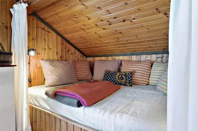 a bed in a wooden cabin with pillows on it at LK1709-Lokken-Ruthsvej-12 in Løkken