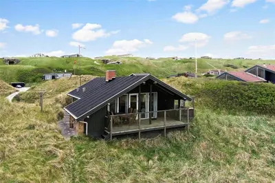 a small house sitting on top of a grassy hill at LK1709-Lokken-Ruthsvej-12 in Løkken