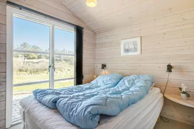 a large bed in a room with a window at LK855-Lokken-Monasvej-7 in Løkken