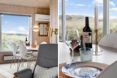 a kitchen and a dining room with a bottle of wine at LK326-Lokken-Monasvej-31 in Løkken