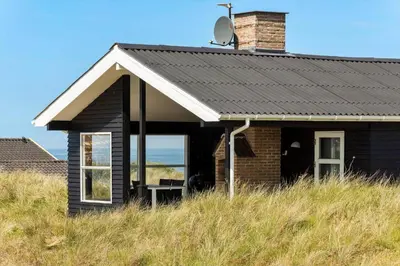a house with a window in a field of grass at LK326-Lokken-Monasvej-31 in Løkken