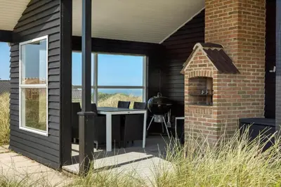 a patio with a table and a grill on a house at LK326-Lokken-Monasvej-31 in Løkken