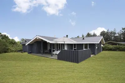 a black house with a lawn in front of it at LK1221-Lokken-Louisevej-5 in Løkken