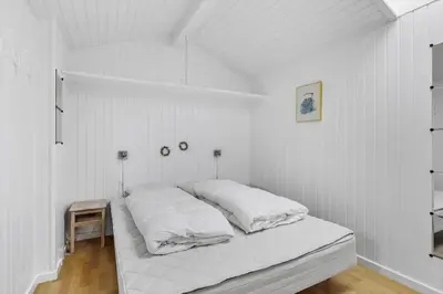 a white bedroom with a bed with white sheets at LK1958-Lokken-Kettrup-Bjerge-Vej-78-A in Løkken