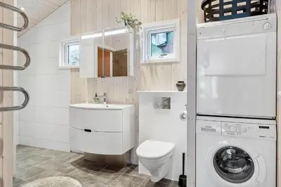 a bathroom with a toilet and a sink and a washing machine at LK1958-Lokken-Kettrup-Bjerge-Vej-78-A in Løkken