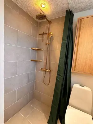 a bathroom with a shower with a toilet and a shower curtain at BL1440-Blokhus-Moreavej-2 in Blokhus