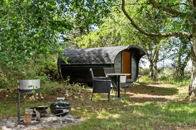 a small cabin with a table and chairs in a forest at BL1440-Blokhus-Moreavej-2 in Blokhus