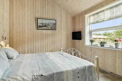 a bedroom with a bed and a window at BL1220-Blokhus-Peter-Andersensvej-21 in Blokhus