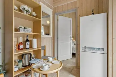a kitchen with a white refrigerator and a table at BL1220-Blokhus-Peter-Andersensvej-21 in Blokhus