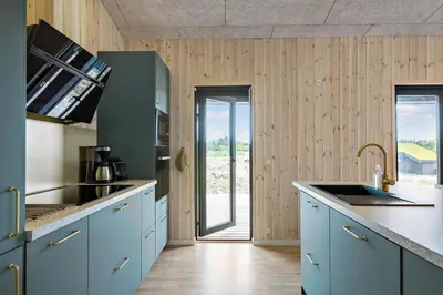 a kitchen with blue cabinets and a door to a patio at BL1557-Saltum-Tolhoj-52 in Saltum
