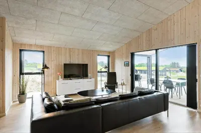 a living room with a black couch and a television at BL1557-Saltum-Tolhoj-52 in Saltum