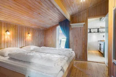 a bedroom with a large bed in a wooden wall at LK850-Lokken-Jorginesvej-8 in Løkken
