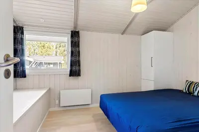 a bedroom with a blue bed and a window at LK504-Lokken-Kristavej-23 in Løkken