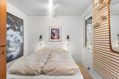 a bedroom with white walls and a bed with a comforter at BL339-Pandrup-Skorr-Karensvej-5 in Pandrup