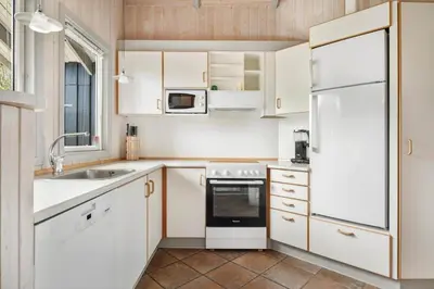 a kitchen with white cabinets and a white refrigerator at LK599-Lokken-Stellavej-16 in Løkken