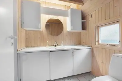a bathroom with a white sink and a mirror at BL1469-Pandrup-Grinden-6 in Pandrup