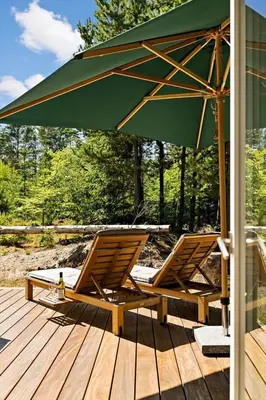 two lounge chairs and an umbrella on a deck at BL1535-Blokhus-Saetergaardsstien-5-A in Blokhus