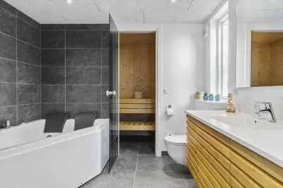a bathroom with a tub and a toilet and a sink at BL1535-Blokhus-Saetergaardsstien-5-A in Blokhus