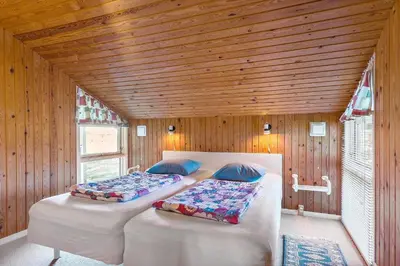 two beds in a room with a wooden ceiling at LK1947-Lokken-Madsinesvej-11 in Løkken