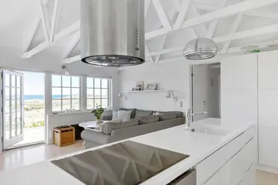 a white living room with a couch and a table at LK1990-Lokken-Lottesvej-27 in Løkken