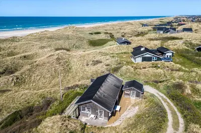 a house on a hill next to the beach at LK1990-Lokken-Lottesvej-27 in Løkken