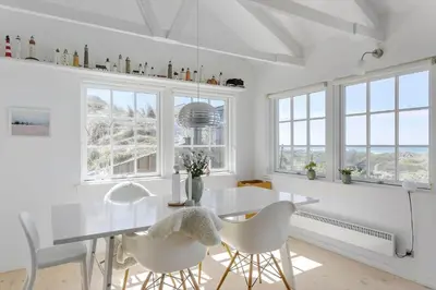 a white dining room with a white table and chairs at LK1990-Lokken-Lottesvej-27 in Løkken