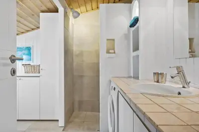 a white bathroom with a sink and a shower at BL124-Blokhus-Klitvejen-75-a in Blokhus