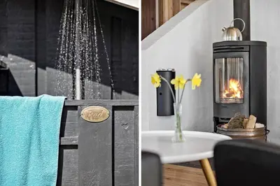 a bathroom with a fireplace and a table with a vase of flowers at BL124-Blokhus-Klitvejen-75-a in Blokhus