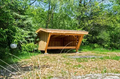 a wooden shelter in the middle of a field at BL1402-Blokhus-Bag-Hojen-57 in Blokhus