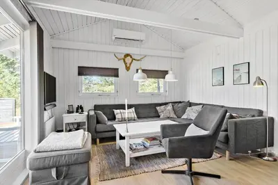 a living room with a couch and a table at BL1402-Blokhus-Bag-Hojen-57 in Blokhus
