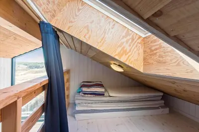 a tiny house with a bed and a window at BL1679-Blokhus-Gormsvej-33 in Blokhus