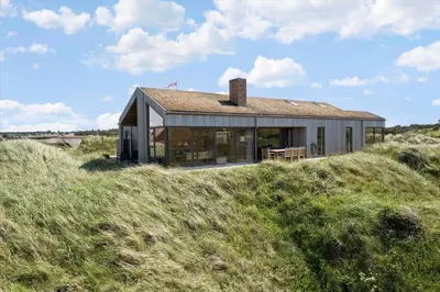 a house sitting on top of a grassy hill at BL1679-Blokhus-Gormsvej-33 in Blokhus