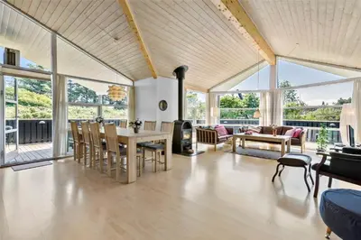 a living room with a table and chairs and windows at LK1813-Lokken-Jorginesvej-3 in Løkken