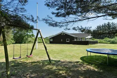 two swings in a yard with a house at LK1813-Lokken-Jorginesvej-3 in Løkken