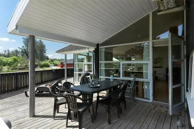 a patio with a table and chairs on a deck at LK1813-Lokken-Jorginesvej-3 in Løkken
